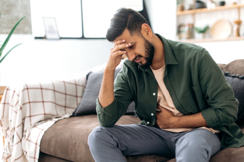 Man with food poisoning holding stomach